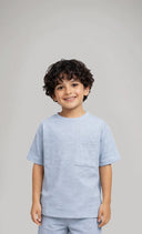 Child wearing a light blue outfit with shorts on a gray background