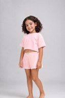 Young girl wearing a pink outfit on a gray background