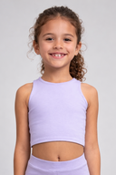 Young girl wearing a light purple athletic outfit on a gray background